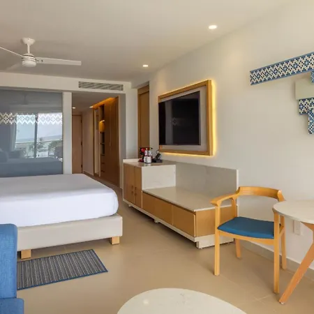 Royalton Splash Riviera Cancun, An Autograph Collection All-Inclusive Resort Puerto Morelos Room photo This is a bright and modern hotel room, featuring a comfortable sleeping area and a stylish workspace.

On the left side, there is a large, neatly made white bed with light blue accents on the pillows, resting on a low platform. Above the bed, a ceil